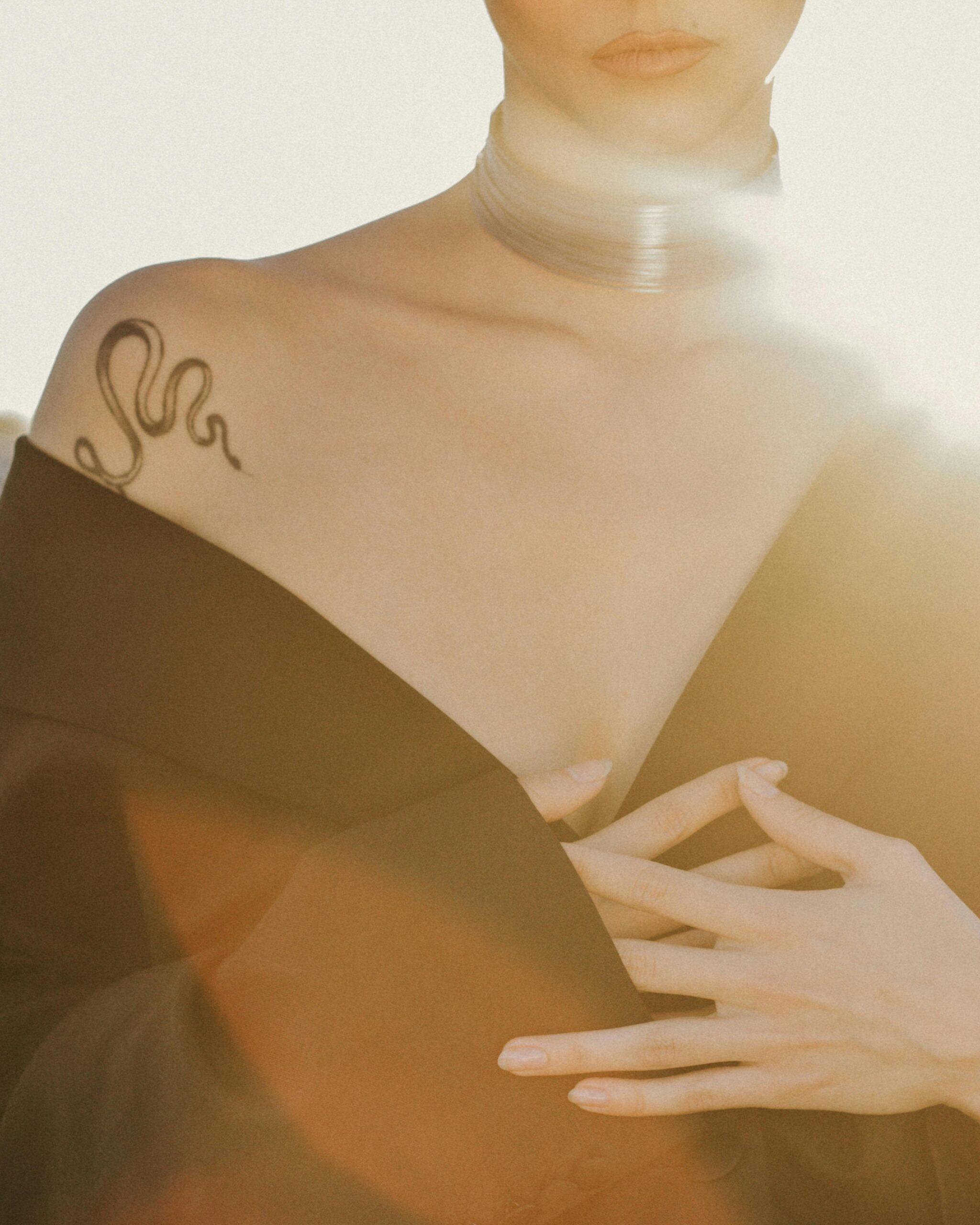 A snake tattoo on a woman's shoulder.