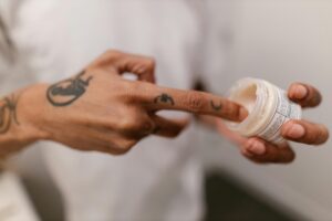 A person applying tatto numbing cream.